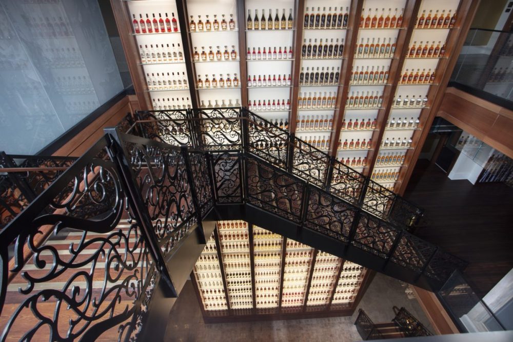 Monumental staircase in front of bottle wall