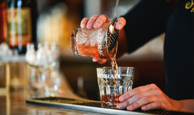 Bartender pouring Sazerac cocktail